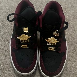 Nike Air Jordan’s burgundy & black low tops with gold accents on the laces.